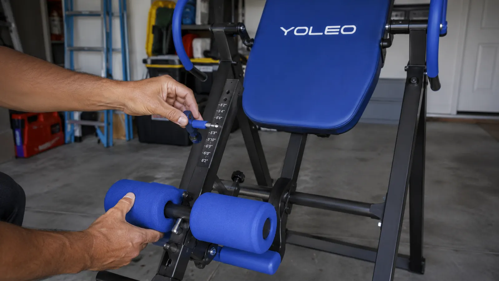 Close-up of hands adjusting the ankle lock and tilt angle on a YOLEO inversion table before use
